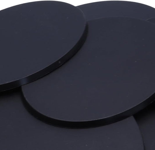 Close-up of black 120mm x 92mm oval plastic miniature bases showing textured top surfaces for large wargaming models, RPG monsters, vehicles, conversions, and scenic basing projects.