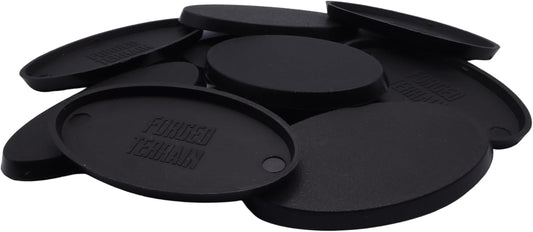 Close-up of black 60mm x 35mm oval plastic miniature bases showing textured top surfaces for cavalry models, mounted figures, bikes, conversions, and hobby basing projects.