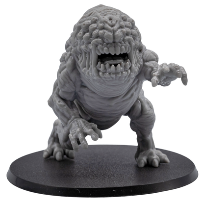 Close front view of an unpainted Aberration monster miniature showing fanged mouth, eye cluster, clawed hands, and detailed sculpt.