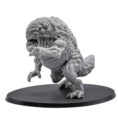 Side view of an unpainted Aberration resin miniature showing muscular body texture, extended claw, rear tail section, and oval base.