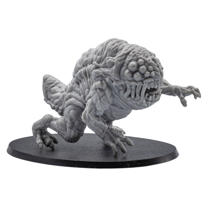 Front angle view of an unpainted Aberration resin miniature showing multiple eyes, open mouth, claws, and oval base.