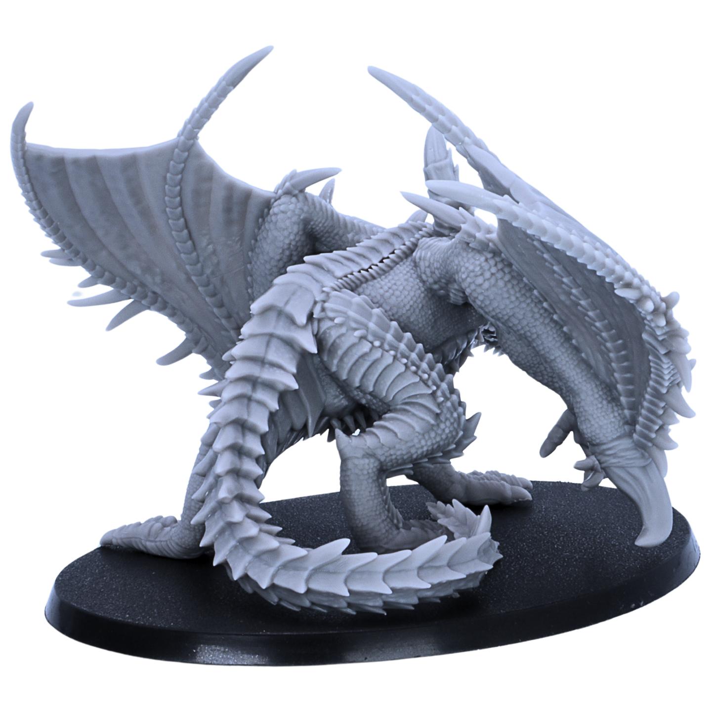 Rear side view of an unpainted Adult Iron Dragon resin miniature showing spiked wings, scaled tail, back armour, and large oval base.