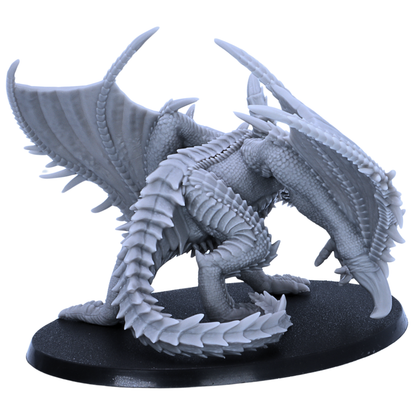 Rear side view of an unpainted Adult Iron Dragon resin miniature showing spiked wings, scaled tail, back armour, and large oval base.