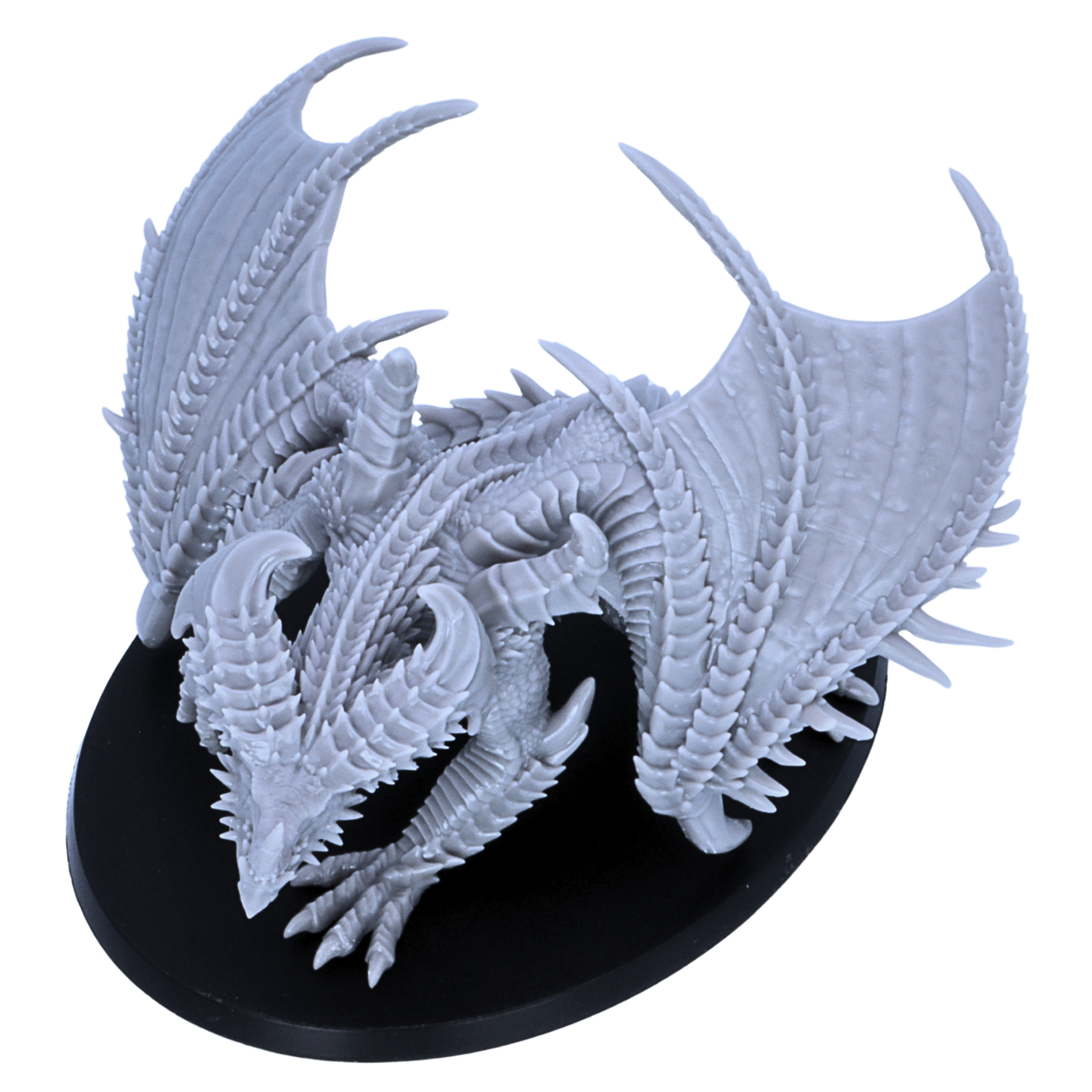 Top view of an unpainted Adult Iron Dragon miniature showing wing span, horn placement, spiked back details, and oval base shape.