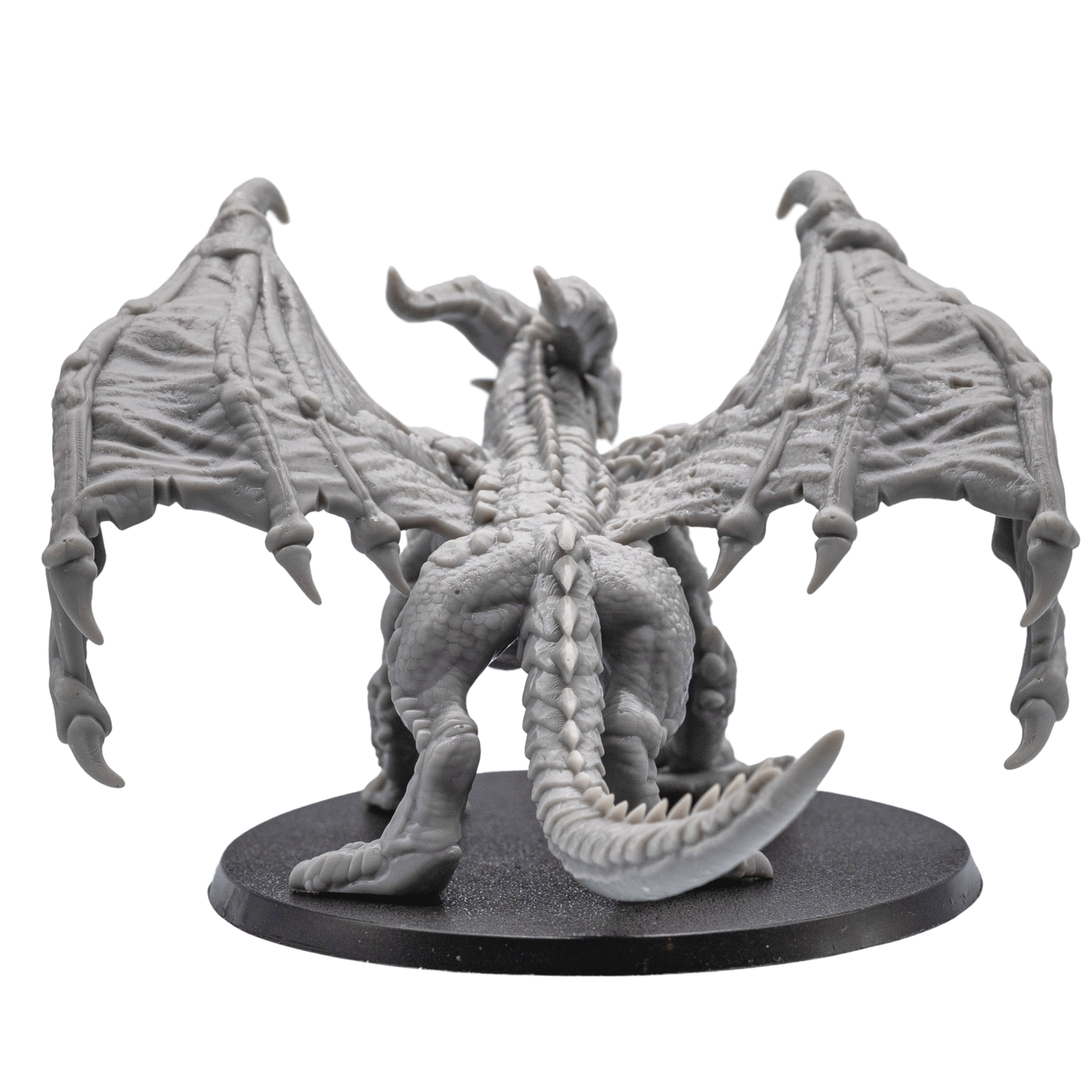 Back view of the unpainted Adult Red Dragon miniature showing folded wings, long tail, and textured scales.