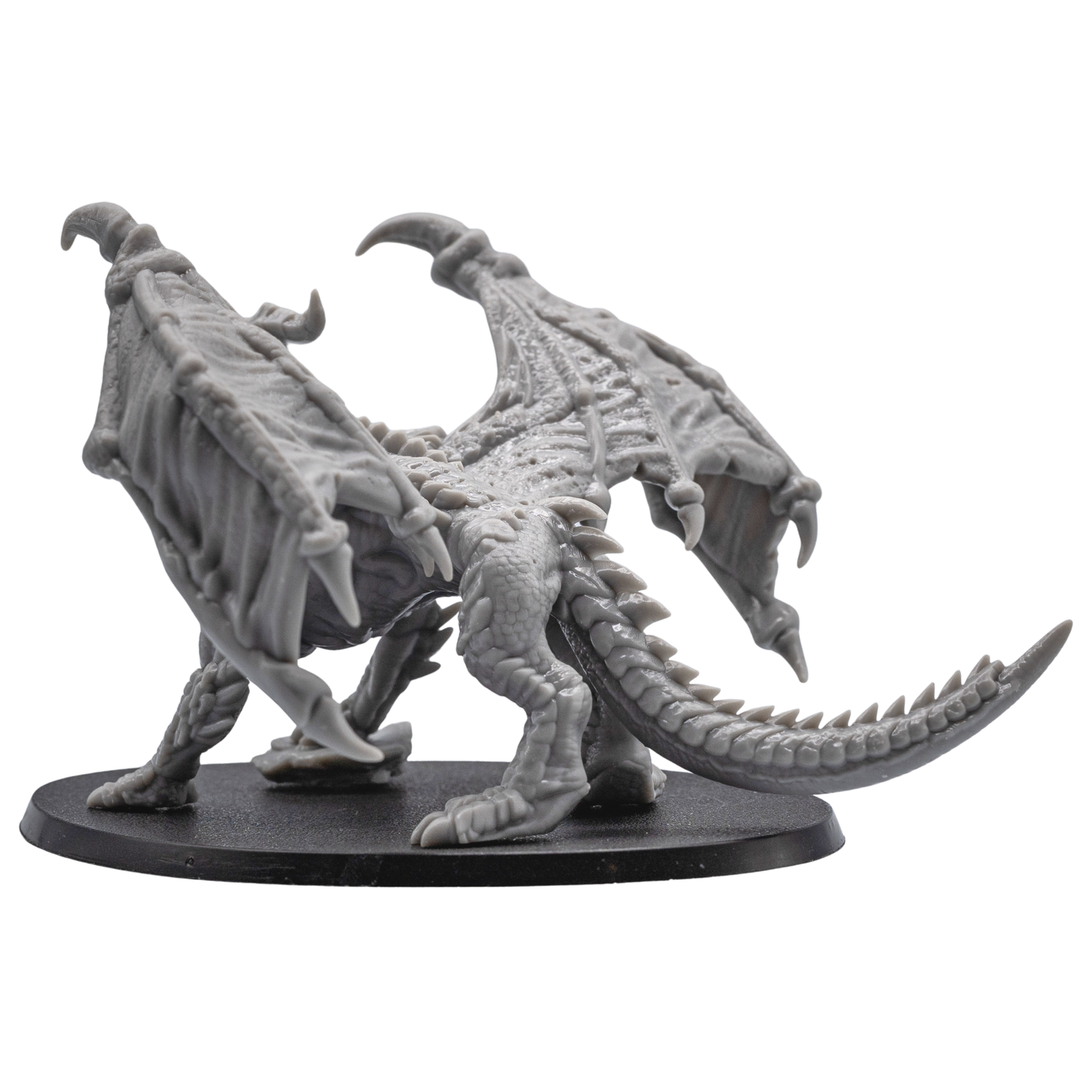 Left side view of the unpainted Adult Red Dragon miniature showing wing membrane, horns, claws, and tail.