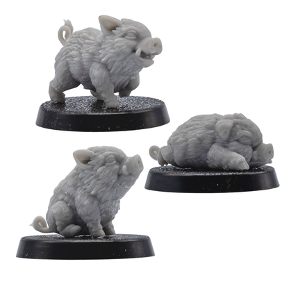 Side view of unpainted Baby Boar Familiar miniatures showing detailed fur texture, small tusks, curled tails, and 25mm round bases.