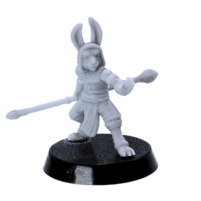 Unpainted rabbitfolk monk miniature holding a long staff in a martial pose on a 25mm round base.