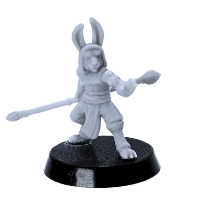 Unpainted rabbitfolk monk miniature holding a long staff in a martial pose on a 25mm round base.