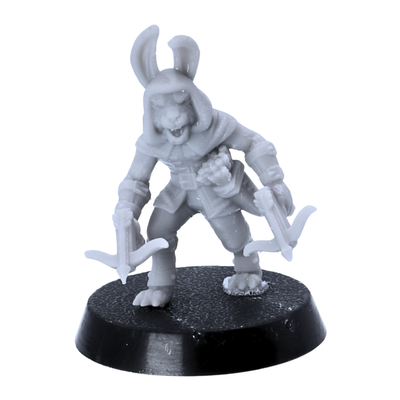 Unpainted hooded bunny rogue miniature wielding two hand crossbows on a 25mm round base.