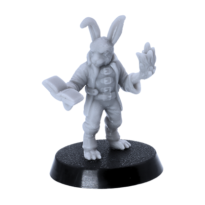 Unpainted bunny scholar or spellcaster miniature holding an open book and raised hand on a 25mm round base.