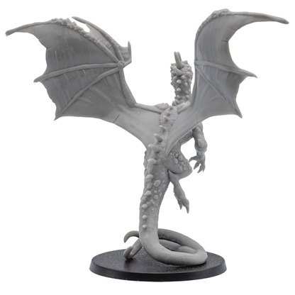 Rear side view of an unpainted Crystal Dragon resin miniature showing wing membrane detail, raised pose, tail curve, and round base.