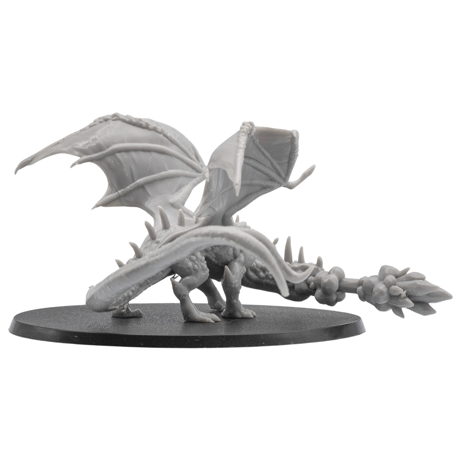 Rear side view of an unpainted Fire Breathing Crystal Dragon miniature showing curled tail, raised wings, crystal details, and flame effect.
