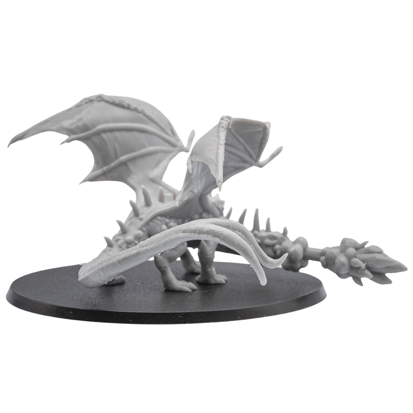 Rear view of an unpainted Fire Breathing Crystal Dragon resin miniature showing raised wings, long tail, and detailed back sculpt.