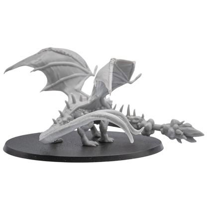 Rear view of an unpainted Fire Breathing Crystal Dragon resin miniature showing raised wings, long tail, and detailed back sculpt.