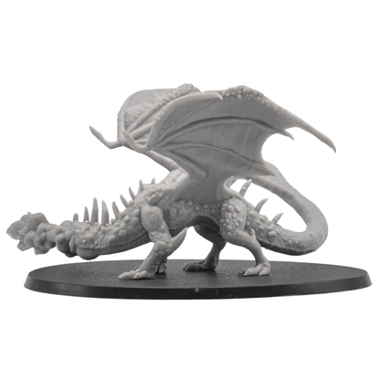 Right side view of an unpainted Fire Breathing Crystal Dragon miniature showing wing membrane detail, long tail, claws, and fire breath effect.