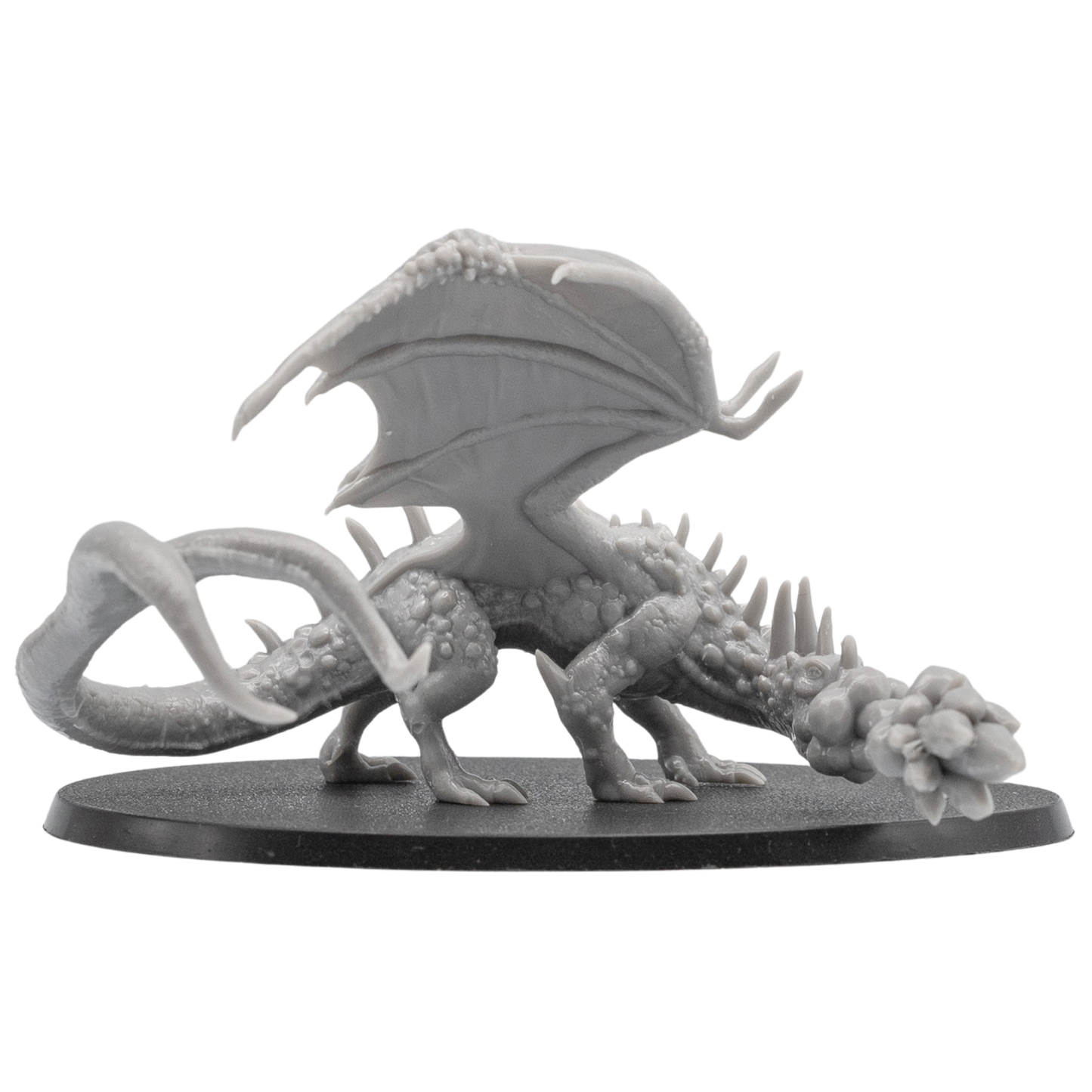 Side angle view of an unpainted Fire Breathing Crystal Dragon miniature with outstretched wings, long tail, crystal spines, and oval base.
