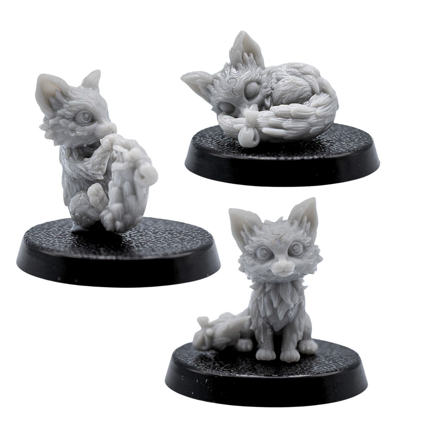 Unpainted Fox Familiars set showing three fox miniatures in sitting, playful, and sleeping poses.