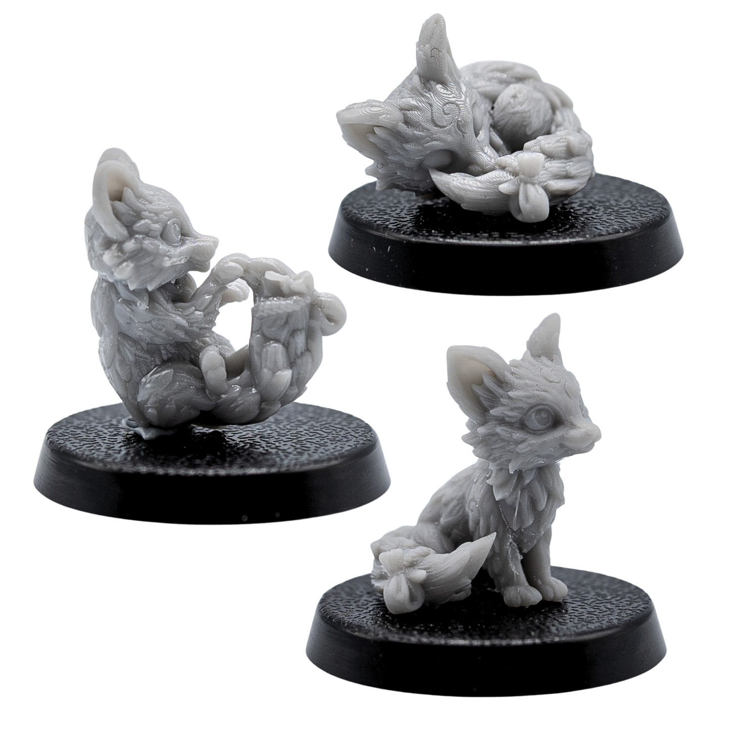 Close-up views of the unpainted Fox Familiars miniatures showing sculpted fur, large ears, and curled tails.