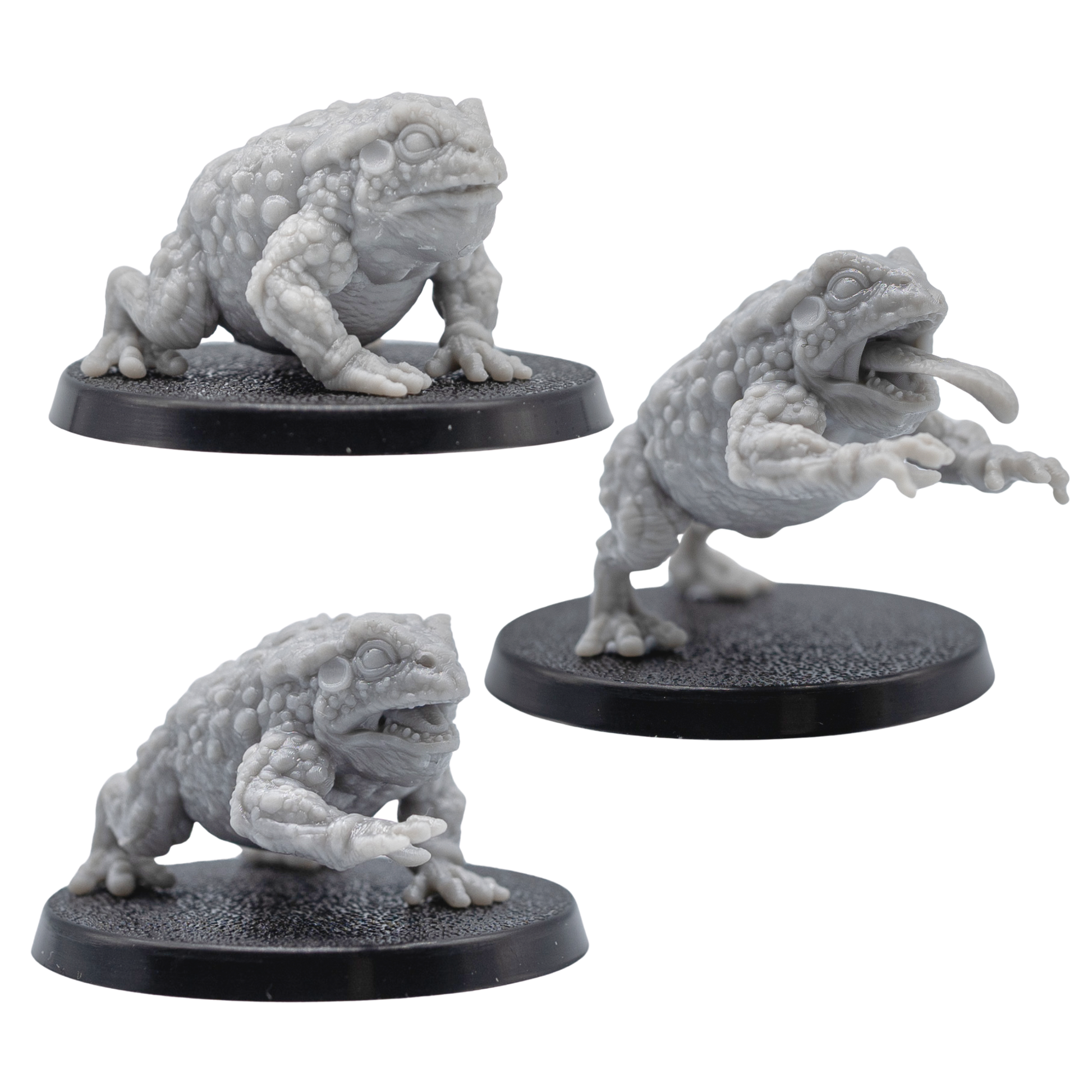 Unpainted Giant Toads showing three grey resin toad miniatures including crouching and tongue-strike poses.