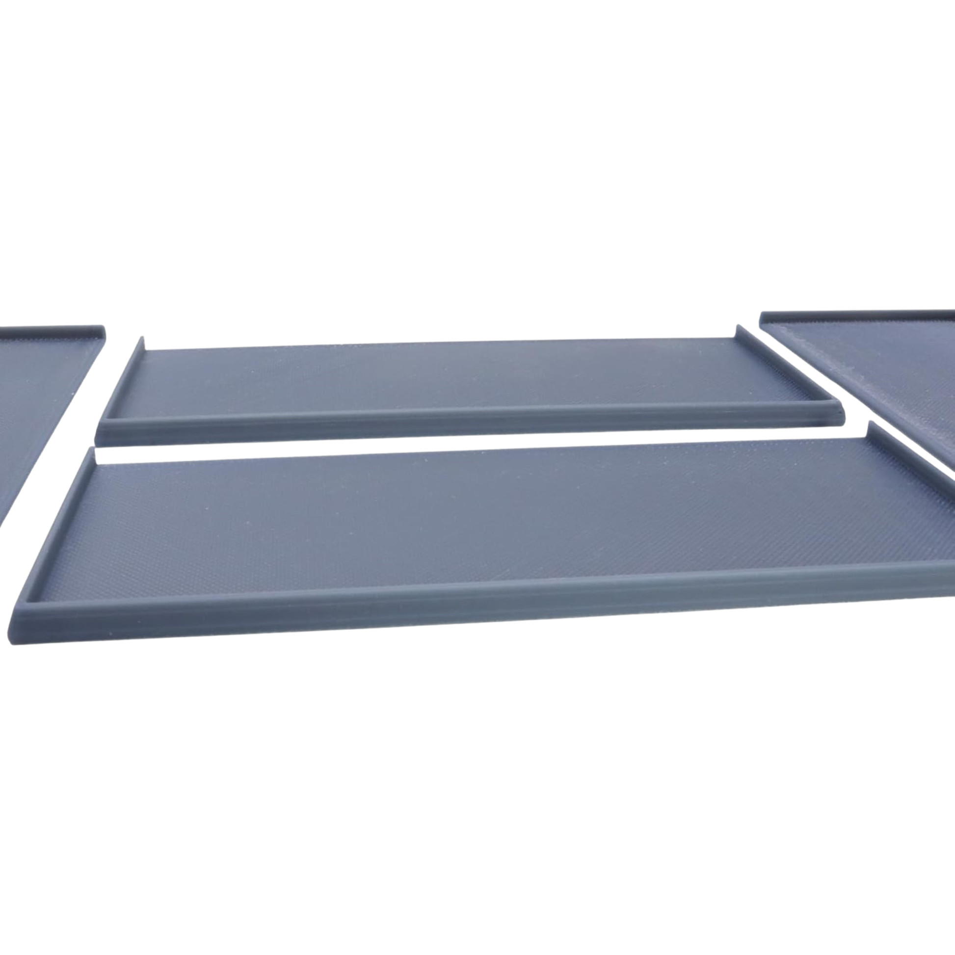 Close-up view showing the low raised edges and flat interior surface of the miniature movement trays.