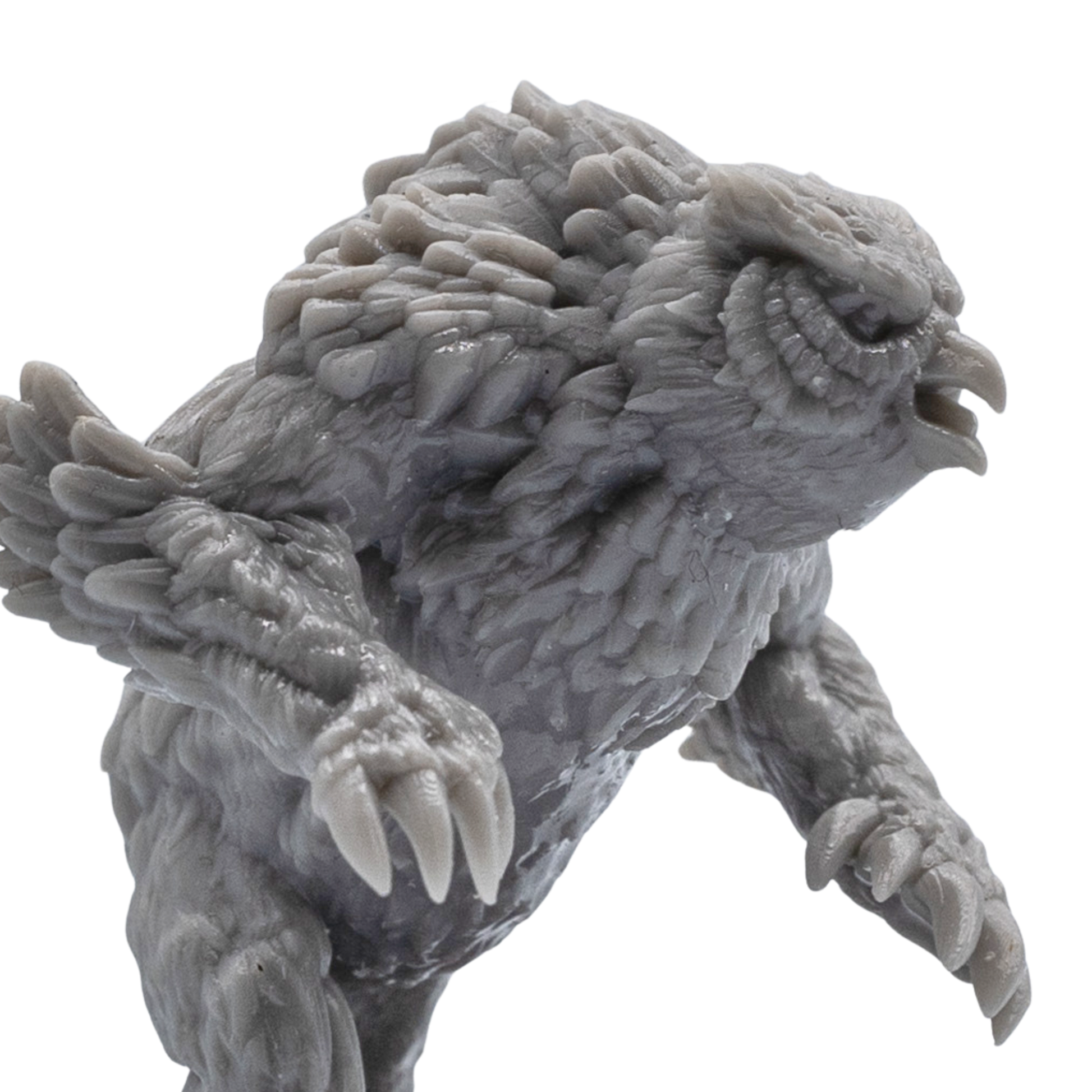 Close-up of an unpainted Owlbear resin miniature showing detailed feathers, claws, beak, and creature sculpt texture.