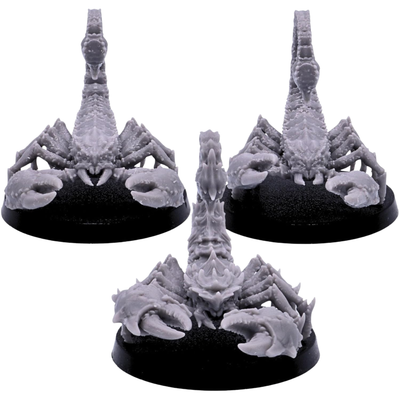 Front views of three unpainted Scorpion miniatures showing massive pincers, plated heads, segmented bodies, and upright stinging tails.