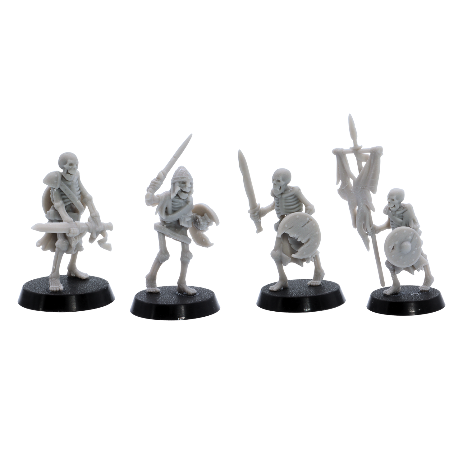 Unpainted skeletal warriors showing four different undead fighter poses with swords, shields, armour, and battle standard.