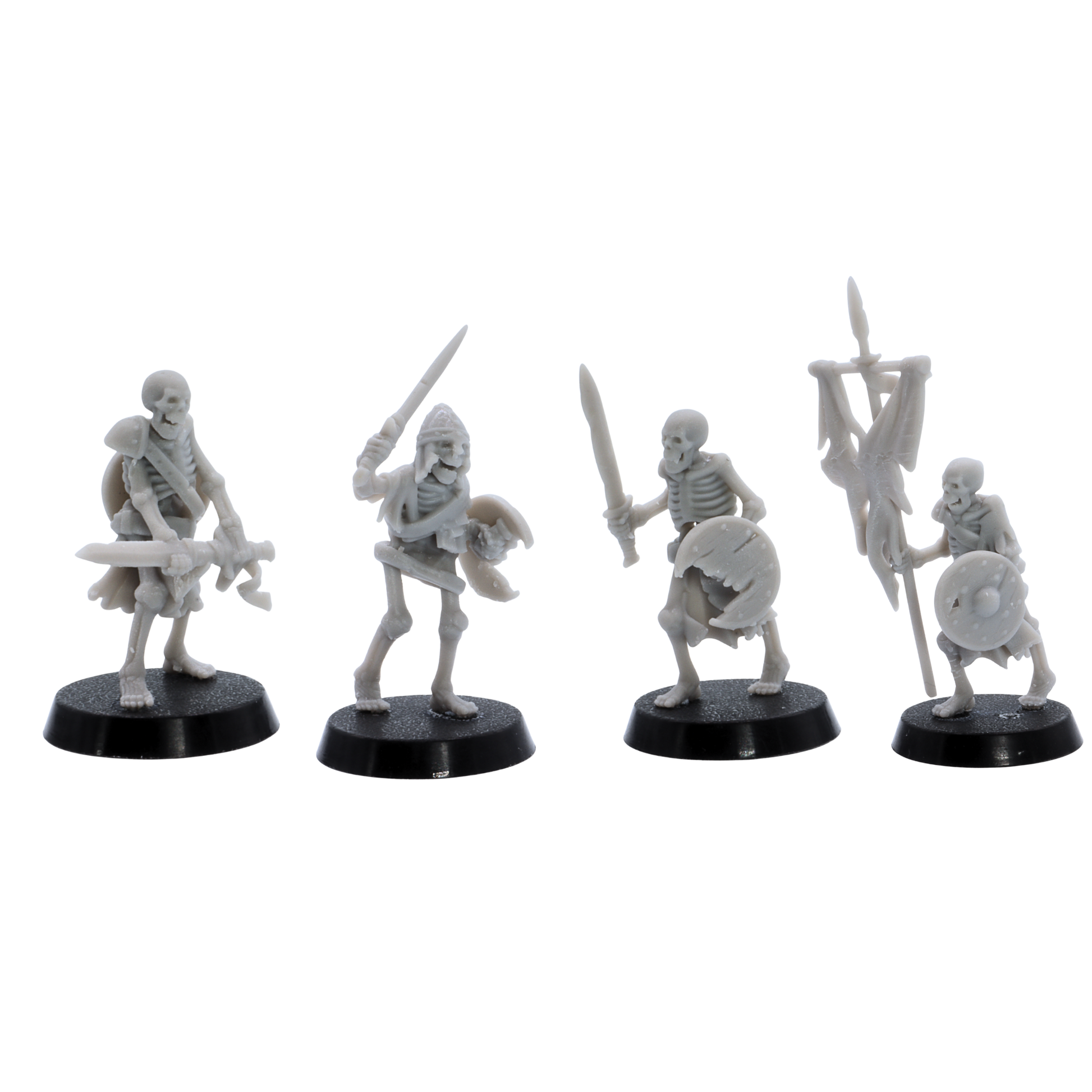 Unpainted skeletal warriors showing four different undead fighter poses with swords, shields, armour, and battle standard.