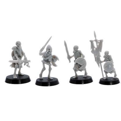 Unpainted skeletal warriors showing four different undead fighter poses with swords, shields, armour, and battle standard.