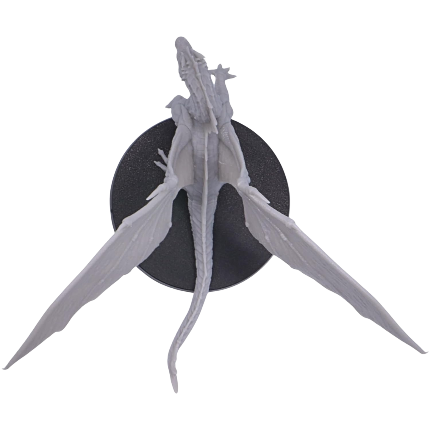 Top view of the unpainted Young Green Dragon miniature showing its long tail, body, large outstretched wings, and 50mm round base.