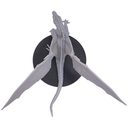 Top view of the unpainted Young Green Dragon miniature showing its long tail, body, large outstretched wings, and 50mm round base.