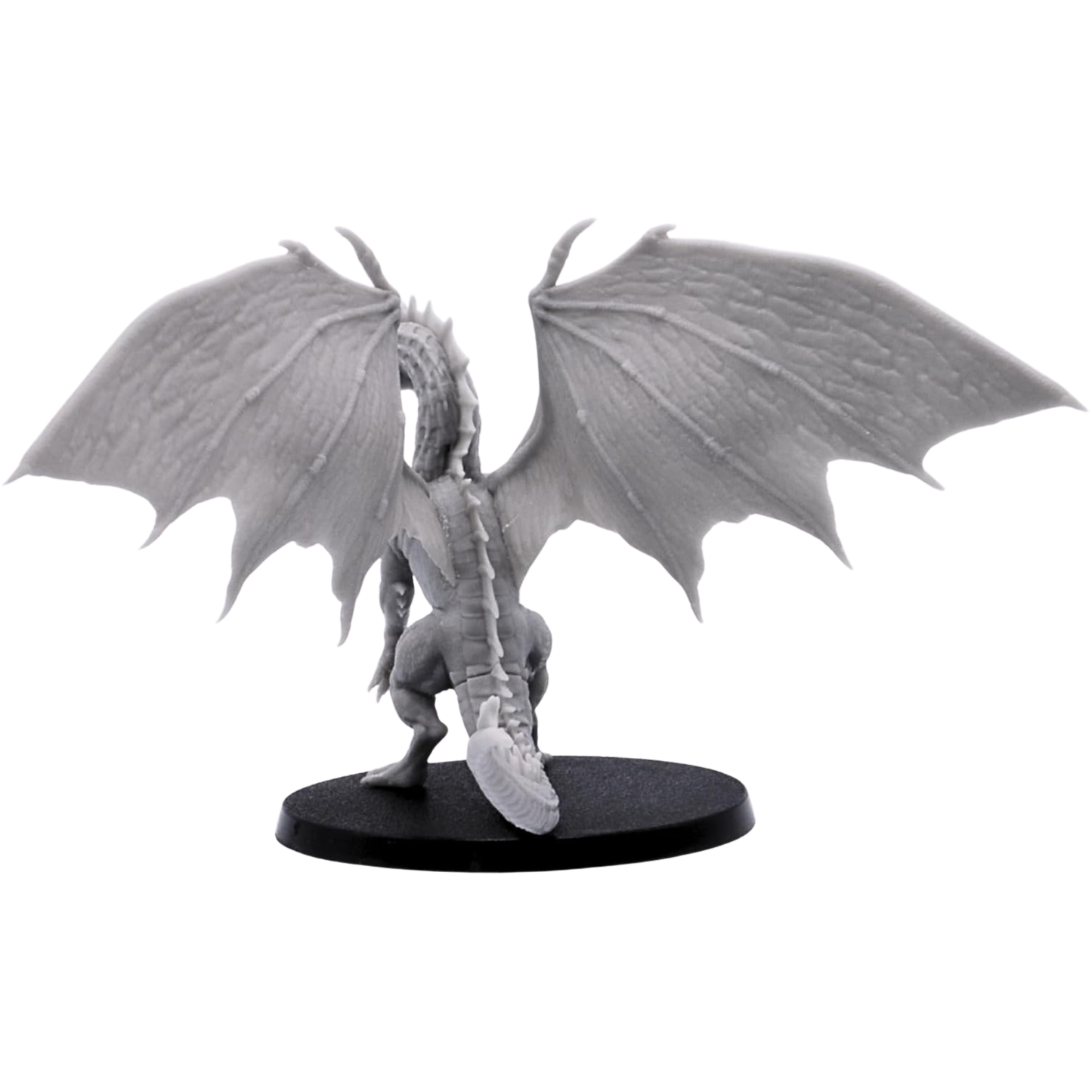 Rear view of the unpainted Young Green Dragon showing broad wings, long scaled spine, tail, hind legs, and raised wing membranes.