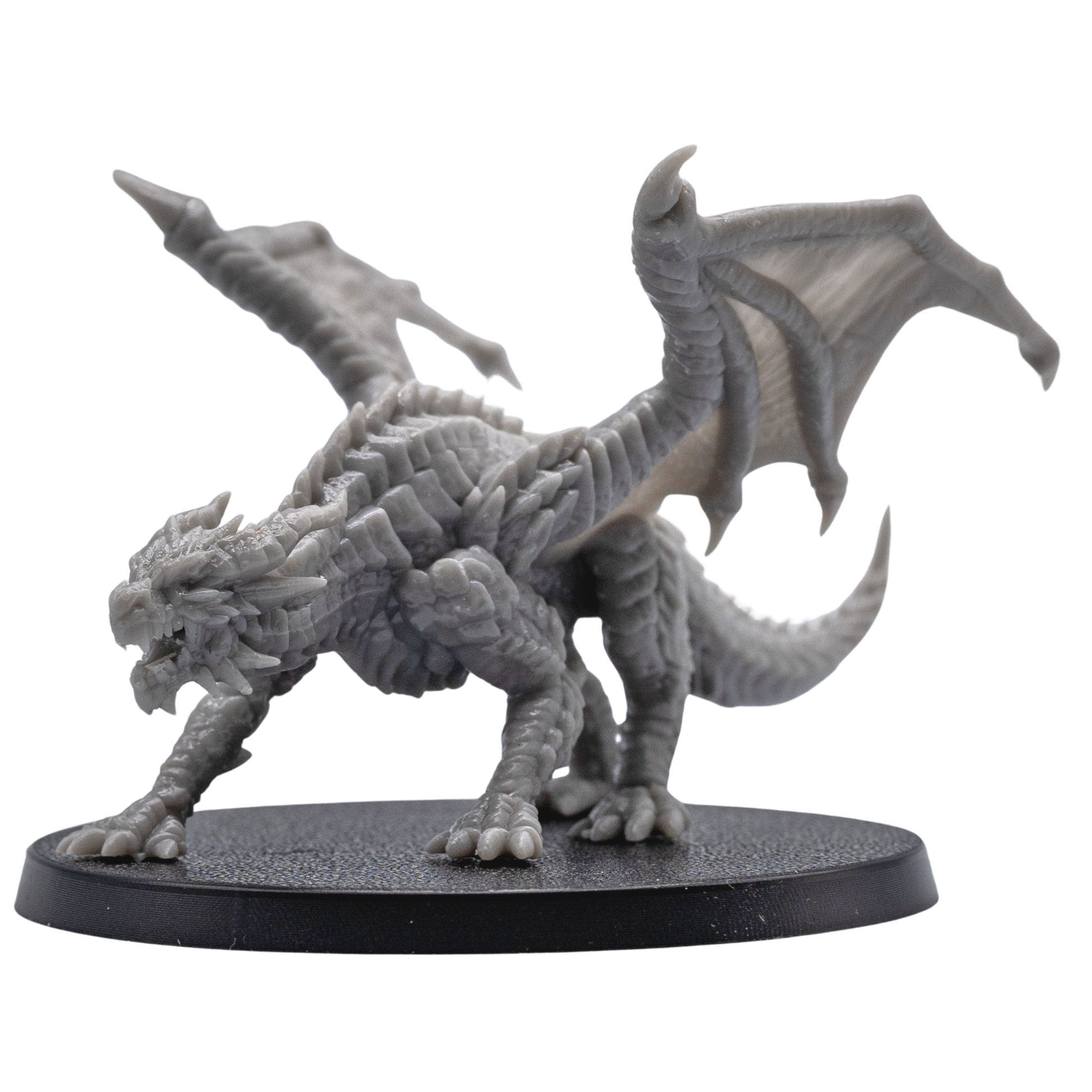 Action pose view of an unpainted Young Red Dragon miniature with raised wings, open jaws, claws, and detailed fantasy creature sculpt.