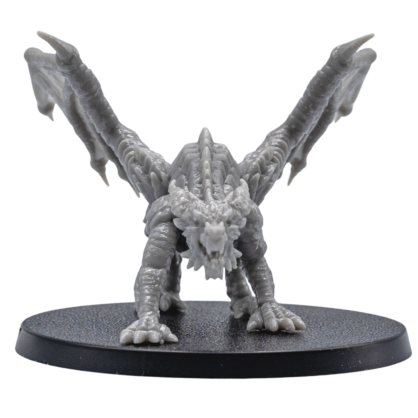 Front view of an unpainted Young Red Dragon resin miniature with open wings, sharp claws, detailed horns, and aggressive pose.