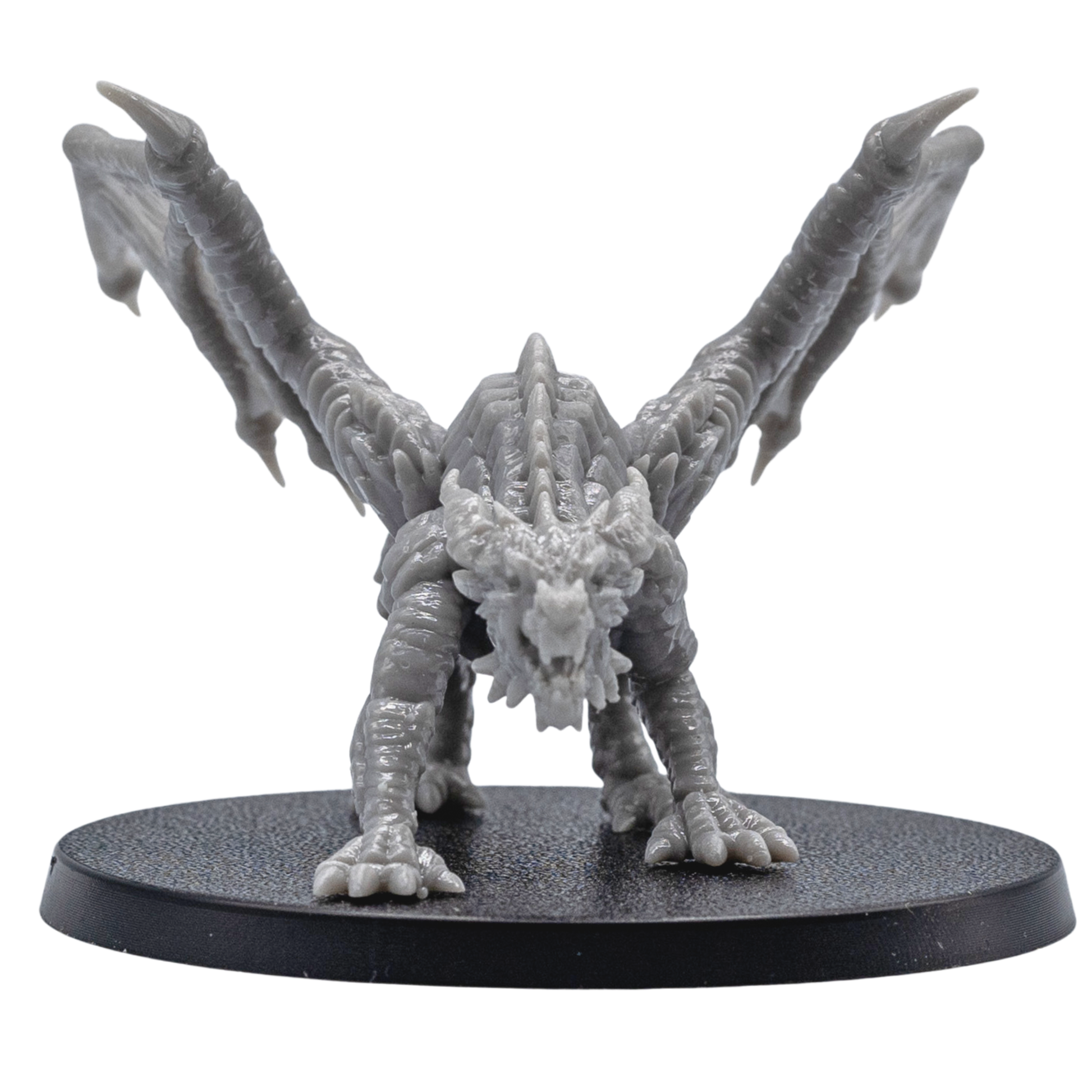 Front view of an unpainted Young Red Dragon resin miniature with open wings, sharp claws, detailed horns, and aggressive pose.