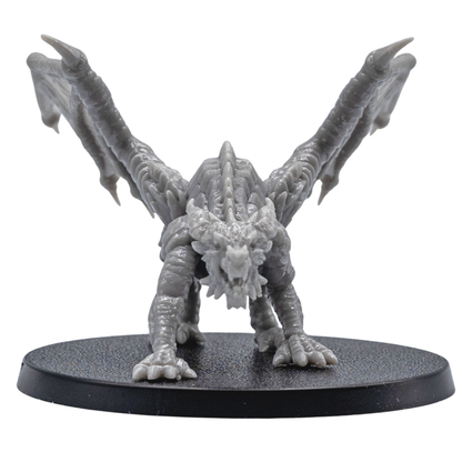 Front view of an unpainted Young Red Dragon resin miniature with open wings, sharp claws, detailed horns, and aggressive pose.